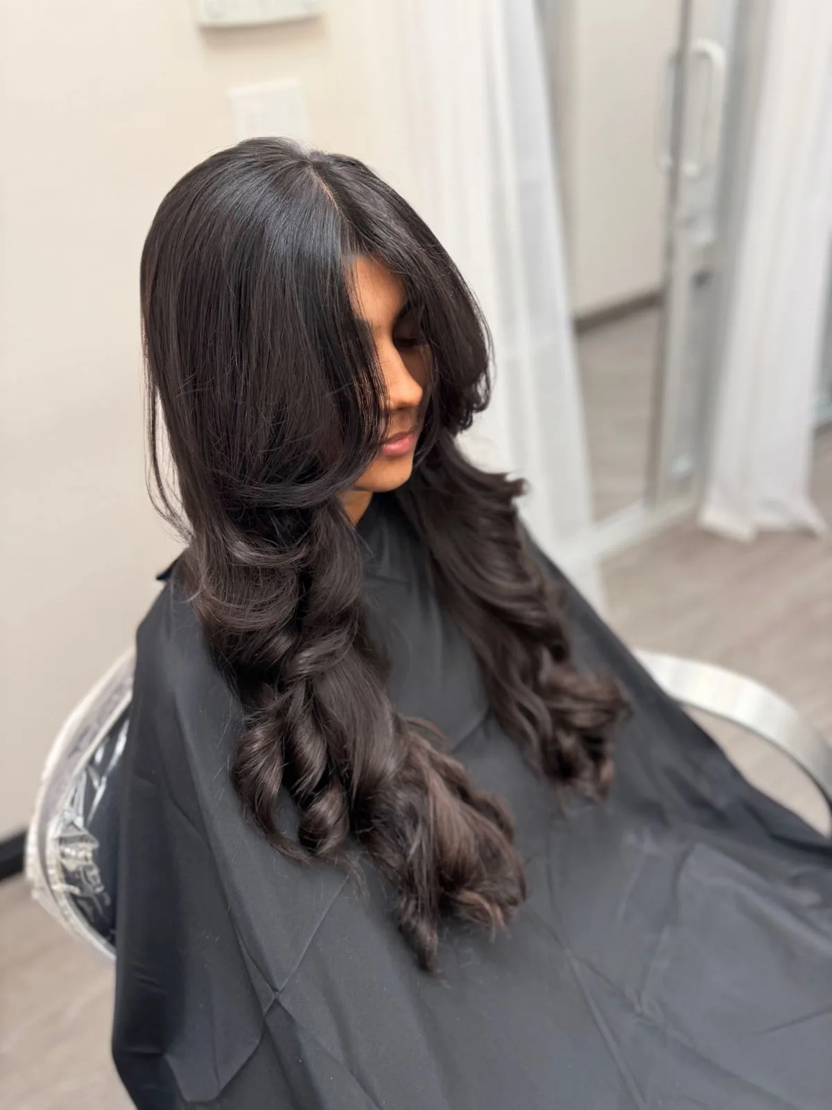 Dark hair styled with voluminous curls and layers